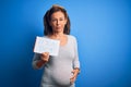 Middle Age Pregnant Woman Expecting Baby Boy Over Blue Background With A Confident Expression On Smart Face Thinking Serious