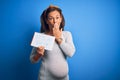 Middle age pregnant woman expecting baby boy over blue background cover mouth with hand shocked with shame for mistake, expression Royalty Free Stock Photo