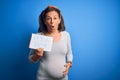 Middle Age Pregnant Woman Expecting Baby Boy Over Blue Background Scared In Shock With A Surprise Face, Afraid And Excited With
