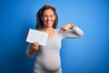 Middle Age Pregnant Woman Expecting Baby Boy Over Blue Background With Surprise Face Pointing Finger To Himself