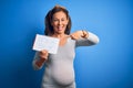 Middle age pregnant woman expecting baby boy over blue background very happy pointing with hand and finger Royalty Free Stock Photo