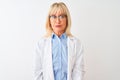Middle age scientist woman wearing glasses standing over isolated white background with serious expression on face Royalty Free Stock Photo