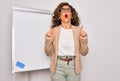 Middle age senior business woman standing on seminar presentation by magnectic blackboard amazed and surprised looking up and Royalty Free Stock Photo