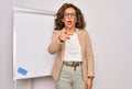 Middle age senior business woman standing on seminar presentation by magnectic blackboard pointing displeased and frustrated to Royalty Free Stock Photo