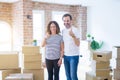 Middle age senior couple moving to a new home with boxes around doing happy thumbs up gesture with hand Royalty Free Stock Photo