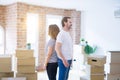 Middle age senior couple moving to a new home with boxes around looking to side, relax profile pose with natural face with Royalty Free Stock Photo