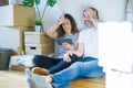 Middle age senior couple moving to a new home using tablet stressed with hand on head, shocked with shame and surprise face, angry Royalty Free Stock Photo