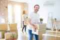 Middle age senior couple moving to a new house, man smiling happy in love with new apartment and holding cardboard boxes Royalty Free Stock Photo