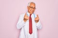 Middle age senior grey-haired doctor man wearing stethoscope and professional medical coat doing money gesture with hands, asking Royalty Free Stock Photo