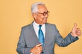 Middle age senior grey-haired handsome business man wearing glasses over yellow background Looking proud, smiling doing thumbs up Royalty Free Stock Photo