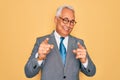 Middle age senior grey-haired handsome business man wearing glasses over yellow background pointing fingers to camera with happy Royalty Free Stock Photo