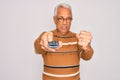 Middle age senior grey-haired man using tv remote control watching television annoyed and frustrated shouting with anger, crazy Royalty Free Stock Photo