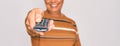 Middle age senior grey-haired man using tv remote control watching television with a happy face standing and smiling with a Royalty Free Stock Photo