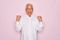 Middle age senior grey-haired man wearing glasses and business shirt over pink background celebrating surprised and amazed for Royalty Free Stock Photo
