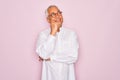 Middle age senior grey-haired man wearing glasses and business shirt over pink background with hand on chin thinking about Royalty Free Stock Photo
