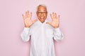 Middle age senior grey-haired man wearing glasses and business shirt over pink background showing and pointing up with fingers Royalty Free Stock Photo