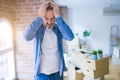 Middle age senior man moving to a new house packing cardboard boxes suffering from headache desperate and stressed because pain Royalty Free Stock Photo