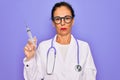 Middle age senior professional doctor woman holding syringe with medical vaccine with a confident expression on smart face