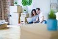 Middle age senior romantic couple in love sitting on the apartment floor with boxes around and using computer laptop smiling happy Royalty Free Stock Photo