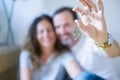 Middle age senior romantic couple in love sitting on the apartment floor with cardboard boxes around and showing house keys Royalty Free Stock Photo