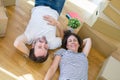 Middle age senior romantic couple lying on the floor, smiling happy for moving to a new house, relaxing and taking a break of Royalty Free Stock Photo