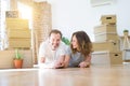 Middle age senior romantic couple lying on the floor, smiling happy for moving to a new house, relaxing and taking a break of