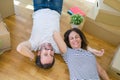 Middle age senior romantic couple lying on the floor, smiling happy for moving to a new house, relaxing and taking a break of