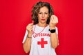 Middle age senior summer lifeguard woman holding whistle over red background Doing Italian gesture with hand and fingers confident