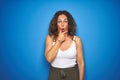 Middle age senior woman with curly hair standing over blue isolated background Looking fascinated with disbelief, surprise and Royalty Free Stock Photo