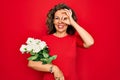 Middle age senior woman holding romantic bouquet of white roses over red background with happy face smiling doing ok sign with Royalty Free Stock Photo