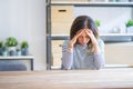 Middle age senior woman sitting at the table at home suffering from headache desperate and stressed because pain and migraine Royalty Free Stock Photo