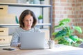 Middle age senior woman sitting at the table at home working using computer laptop with a confident expression on smart face Royalty Free Stock Photo