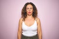 Middle age senior woman standing over pink isolated background with serious expression on face Royalty Free Stock Photo