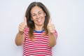 Middle age senior woman standing over white isolated background approving doing positive gesture with hand, thumbs up smiling and Royalty Free Stock Photo