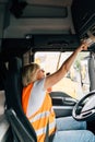 Middle age truck driver woman talking on radio and turns on tachograph, trucker occupation in Europe for females Royalty Free Stock Photo