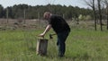 Unskilled man in black t-shirt try to chop firewood with small ax unsuccessfully