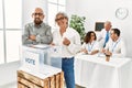 Middle age voter couple smiling happy putting vote in voting box at electoral center