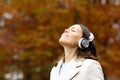 Middle age woman breathing fresh air with headphones in autumn Royalty Free Stock Photo