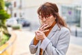 Middle age woman business executive smoking cigarette at park