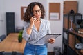 Middle age woman business worker talking on smartphone reading document at office Royalty Free Stock Photo