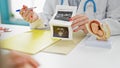 Middle age woman doctor and patient showing ultrasound baby at clinic Royalty Free Stock Photo