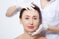 Middle age woman getting spa treatment. Face massage. Anti aging botox and collagen. Plastic surgery concept with doctor hands iso Royalty Free Stock Photo