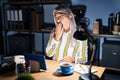 Middle age woman with grey hair working at the office at night bored yawning tired covering mouth with hand Royalty Free Stock Photo