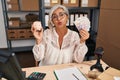 Middle age woman with grey hair working at small business ecommerce holding piggy bank and zloty looking at the camera blowing a Royalty Free Stock Photo