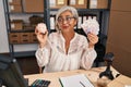Middle age woman with grey hair working at small business ecommerce holding piggy bank and zloty smiling looking to the side and Royalty Free Stock Photo