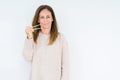 Middle age woman holding asian chopsticks over isolated background with a confident expression on smart face thinking serious Royalty Free Stock Photo