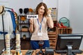 Middle age woman holding banner with open text at retail shop annoyed and frustrated shouting with anger, yelling crazy with anger