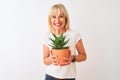Middle age woman holding cactus pot standing over isolated white background with a happy face standing and smiling with a Royalty Free Stock Photo