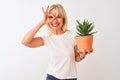 Middle age woman holding cactus pot standing over isolated white background with happy face smiling doing ok sign with hand on eye Royalty Free Stock Photo