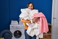 Middle age woman holding dirty laundry ready to put it in the washing machine smiling with a happy and cool smile on face Royalty Free Stock Photo